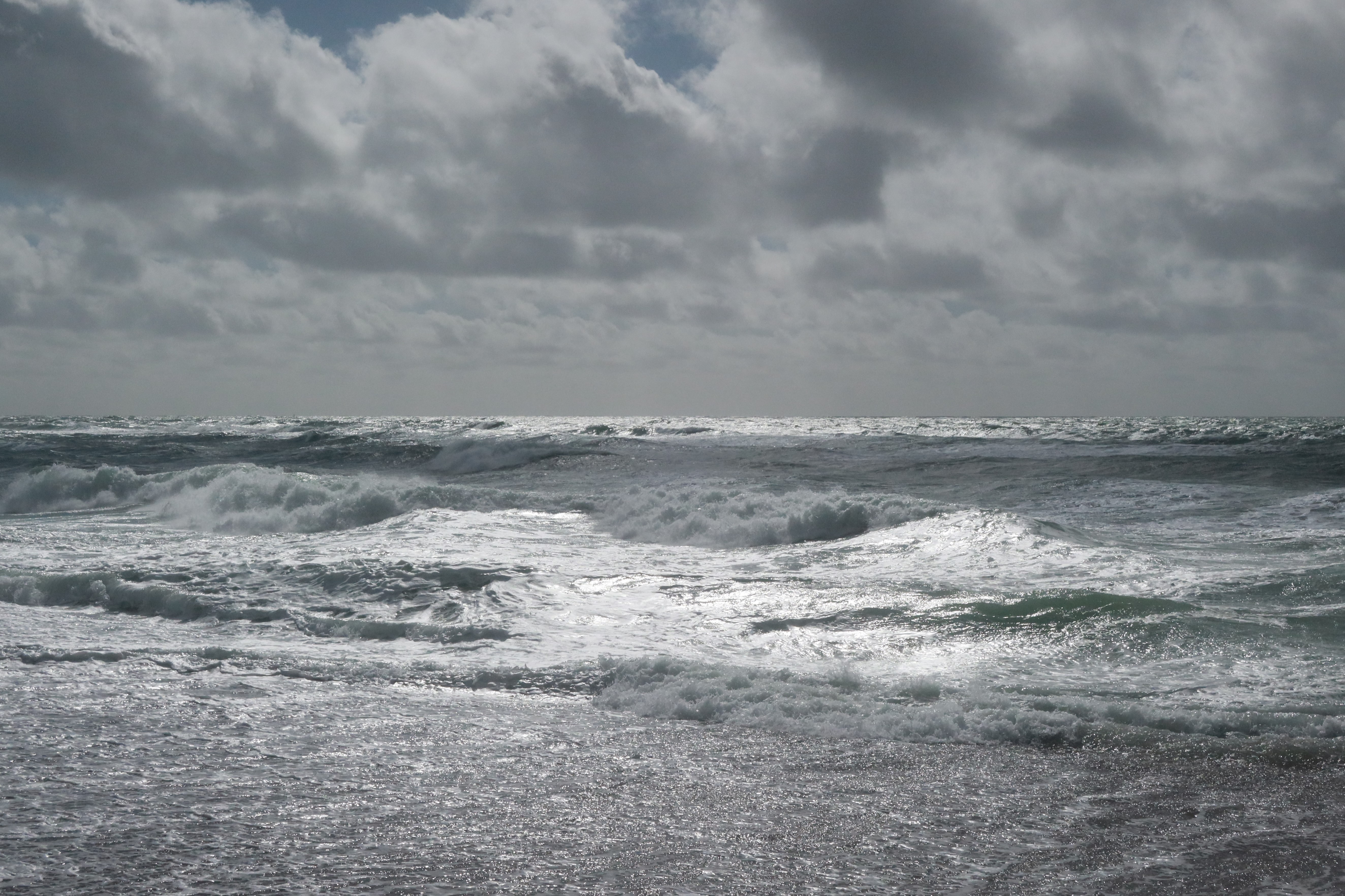 Waves on a beach at the North Sea, the sky is overcast.