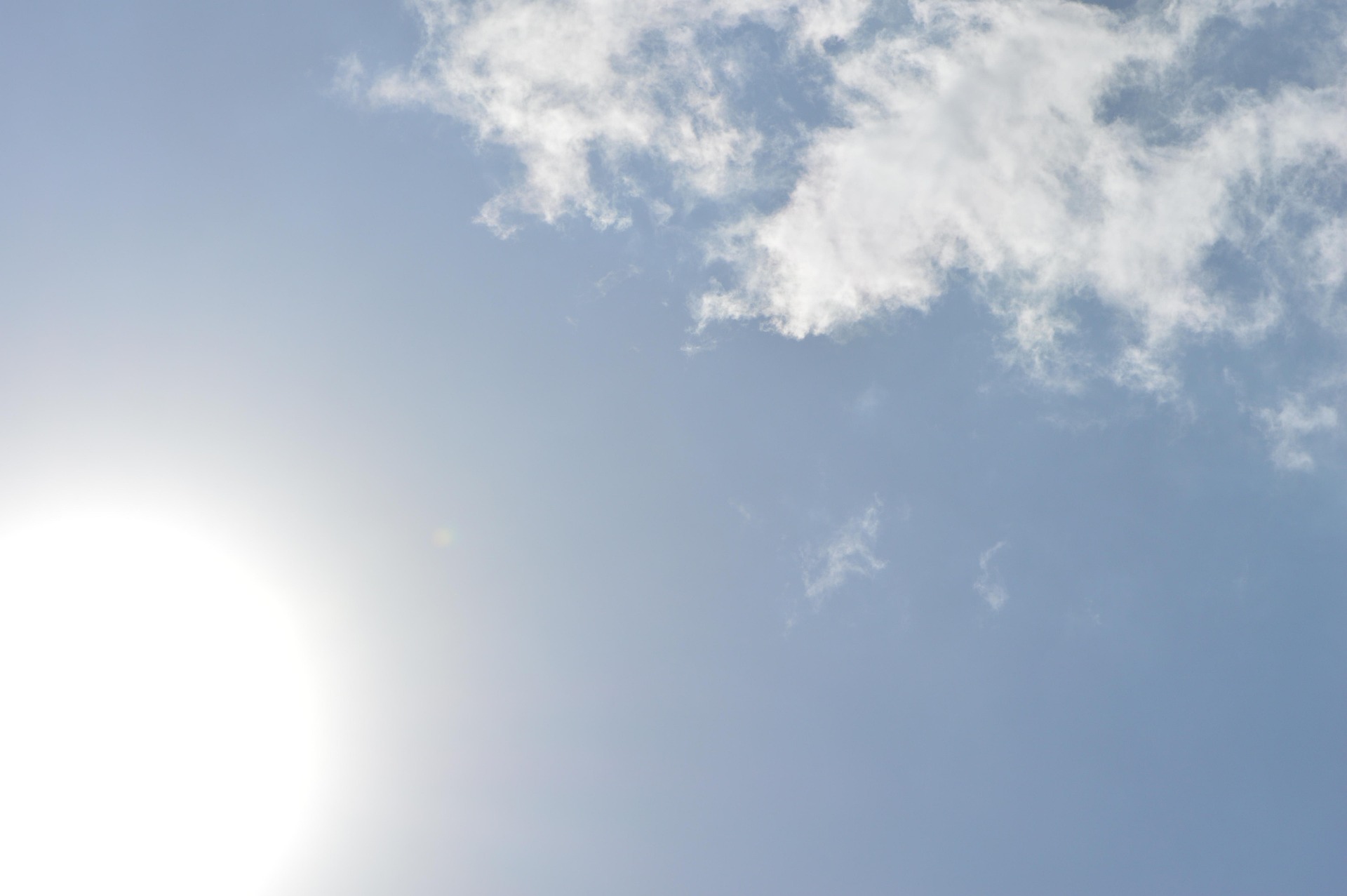 Credit: Pixabay blauer Himmel mit gleißender Sonne unten links und lockerer Wolke oben rechts
