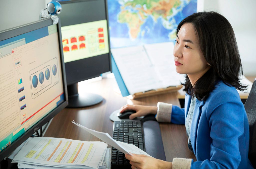 Photo of Sarah Kang at the desk with two displays in front