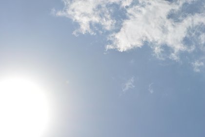 Credit: Pixabay blue sky with glistening sun below left and loose cloud above right