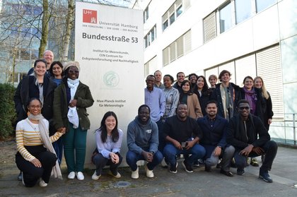 Eine Gruppe junger Nachwuchsforschender ist vor dem Max-Planck-Institut für Meteorologie in der Bundesstraße 53 in Hamburg versammelt.